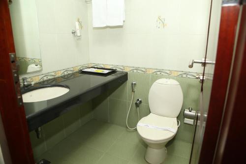 a bathroom with a toilet and a sink at Kallada Residency in Kodungallūr