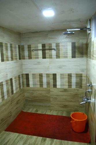 a bathroom with a shower with a red rug at Malayoram Heritage Villa Munnar in Kūmudi