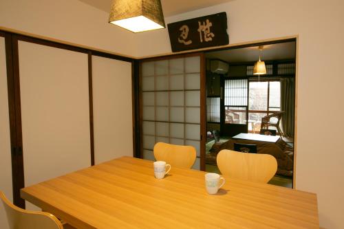 a dining room with a wooden table and chairs at Holy's House in Kyoto