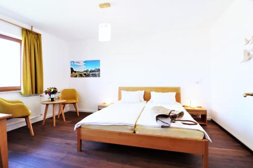 a bedroom with a bed and two chairs at BioWeingut & Landhotel Gänz in Hackenheim