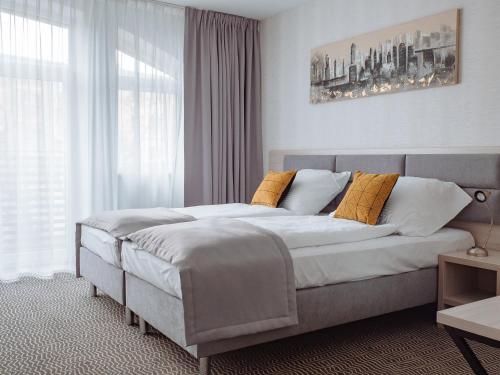 une chambre avec un grand lit avec des oreillers jaunes dans l'établissement Hotel Chrobrego9, à Bolesławiec
