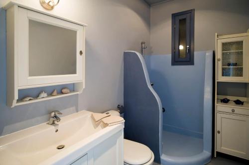 a bathroom with a sink and a toilet and a tub at Luxury Cycladic Villa-Enjoy Infinity Pool Sunsets in Koundouros
