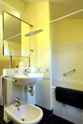a bathroom with a sink and a mirror and a tub at Maison de maître à BRAM # Jacuzzi in Bram