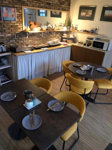 ein Restaurant mit zwei Tischen und Stühlen und einer Theke in der Unterkunft Pension de Zeeschelp in Domburg
