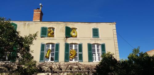 a building with gold signs on the side of it at Maison de maître à BRAM # Jacuzzi in Bram