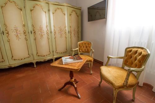 a room with two chairs and a dresser and a table at B&B PALAZZI in Florence