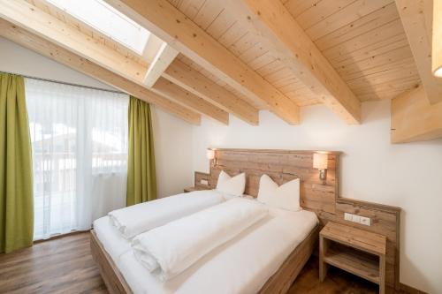 - une chambre avec un grand lit blanc et une fenêtre dans l'établissement A Casa Saphir Appartement-Hotel, à Sölden