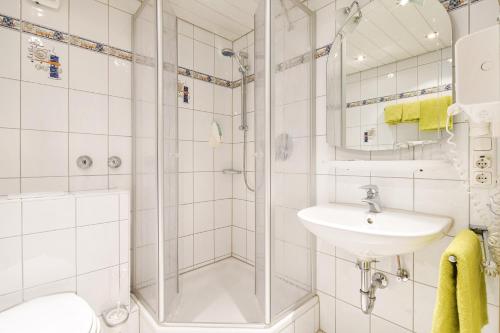 een witte badkamer met een douche en een wastafel bij Land-gut-Hotel Landgasthof Zum Schildhauer in Halfing