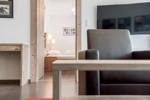 a living room with a chair and a mirror at A Casa Saphir Appartement-Hotel in Sölden