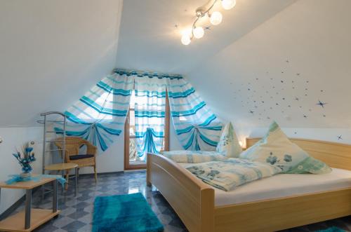 a bedroom with a bed and a window with blue curtains at Haus Sonnenschein in Gößweinstein