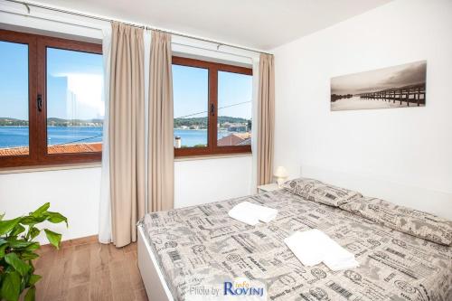 a bedroom with a bed with a view of the ocean at Ondina 2 in Rovinj