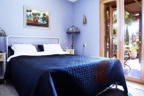 um quarto azul com uma cama com um cobertor azul em Andromeda Hill Jaffo Bedroom & Living Room Deluxe em Tel Aviv