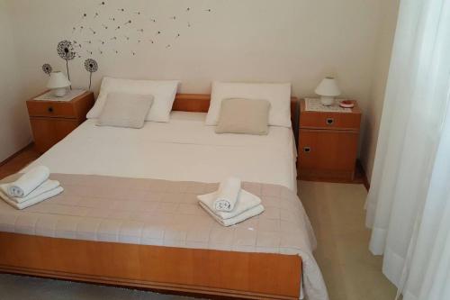 a bedroom with a large white bed with two night stands at Apartmani Ante in Posedarje