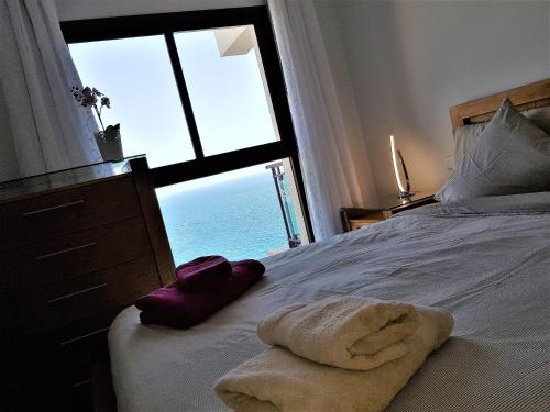 Su Eminencia - 2 bedrooms 5 star Playa Del Cura في بلايا ديل كورا: غرفة نوم مع سرير وإطلالة على المحيط