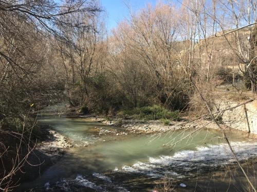 a river with snow and trees and a bridge at Apartamentos Duquesa Sierra Nevada in Pinos Genil