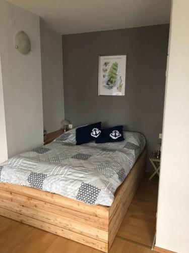 een slaapkamer met een houten bed met blauwe kussens erop bij City Weserblick in Bremerhaven