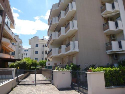 eine Reihe von Apartmenthäusern mit einem Zaun davor in der Unterkunft Appartamento Iolanda in Tortoreto Lido