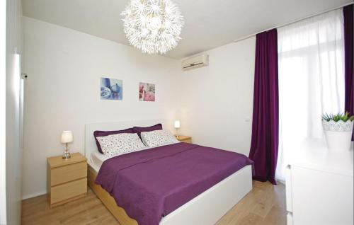 - une chambre avec un lit violet et un lustre dans l'établissement Apartment MIVA, à Brela