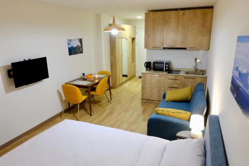 グダウリにあるGUDASKI Apartments, New Gudauri LOFT2 & LOFT1の青いソファとキッチンのあるリビングルーム
