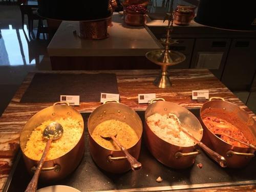 vier pannen met eten op een tafel met lepels bij Bellavista Resort Munnar in Munnar