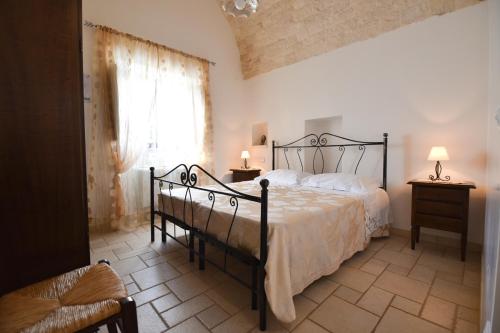 a bedroom with a black bed and a window at Trulli e Cummerse in Locorotondo