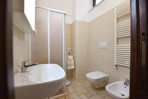 a white bathroom with a sink and a toilet at Trulli e Cummerse in Locorotondo