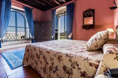 a bedroom with a bed and a window at Hacienda el Santiscal in Arcos de la Frontera