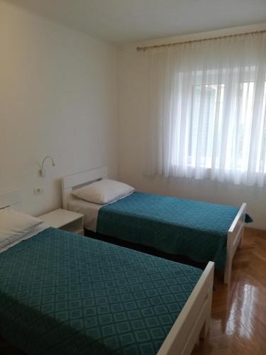 1 dormitorio con 2 camas y una ventana con cortinas en Tony apartment Split, en Split