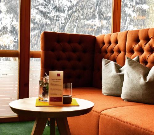 a coffee table with a box on it next to a couch at Vivea Hotel Umhausen im Ötztal in Umhausen