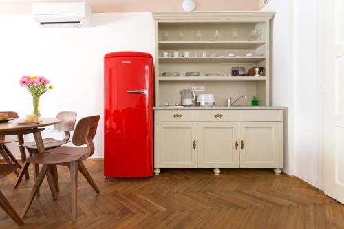 an old red refrigerator in a kitchen with a table at Barbo Palace Apartments and Rooms in Ljubljana