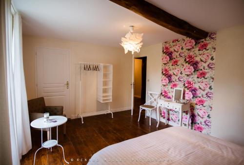 Schlafzimmer mit einem Bett, einem Schreibtisch und einem Tisch in der Unterkunft Le Moulin de Bois Coûtant in Vivonne