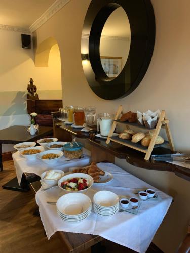 a buffet with plates and pastries and a mirror at The Auld Kirk in Ballater