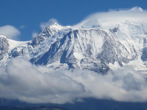 a snow covered mountain with clouds in front of it at L'Onyx - Domaine de Nant Cruy in Sallanches