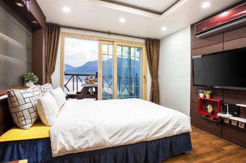 ein Schlafzimmer mit einem großen Bett und einem großen Fenster in der Unterkunft oneday in geoje in Geoje