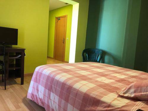 a bedroom with a bed and a desk and a television at Mirador El Silo in Bello