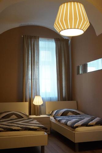 a bedroom with two beds and a window and a lamp at Gästehaus Familie Löffler - Ferienwohnung am Stadtplatz in Litschau in Litschau