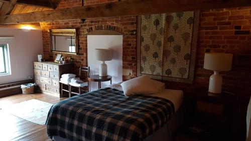 ein Schlafzimmer mit einem Bett und einer Ziegelwand in der Unterkunft The Granary in Salford