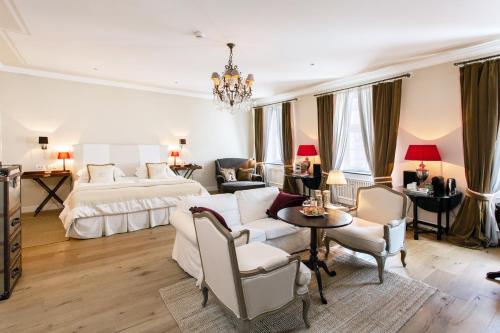 a bedroom with a bed and a couch and a table at Lesar Hotel Angel - Member of Hip Hotels in Ljubljana