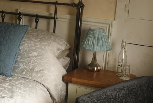 a bedroom with a bed and a lamp on a table at The Old Smithy Bed & Breakfast in Clovelly
