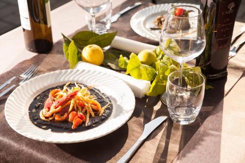 a table with a plate of food and a bottle of wine at L'Albero in Porto Empedocle