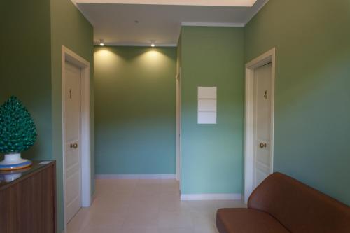 a living room with green walls and a couch at L'Albero in Porto Empedocle