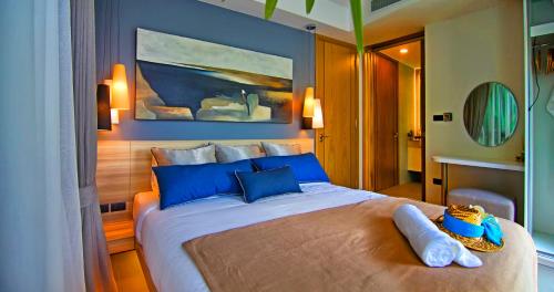 a bedroom with a large bed with two towels on it at Oceanstone by Holy Cow, 2-BR, 60 m2, tree view in Bang Tao Beach