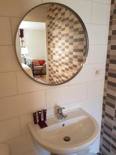 une salle de bain avec un lavabo et un miroir dans l'établissement Auberge Henri IV, à Ségur-le-Château