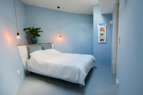 1 dormitorio con paredes azules y 1 cama con sábanas blancas en Sailor Suite Coaster Mado, en Ámsterdam