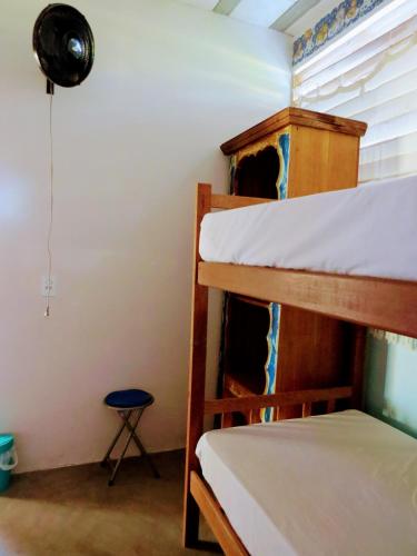 a room with two bunk beds and a stool at Tribo de Gaia in Itaúnas