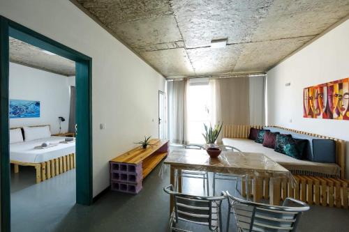 Cette chambre comprend un lit, une table et des chaises. dans l'établissement Salzen - Portas do Sol, à Santa Maria