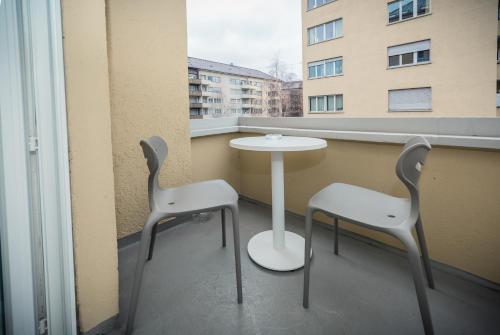 two chairs and a table on a balcony with a window at Zurich Furnished Homes in Zürich