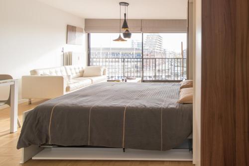 a bedroom with a large bed and a living room at Studio Juan les Pins in Ostend