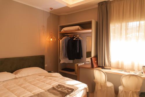 a bedroom with a bed and a desk and a window at L'Albero in Porto Empedocle