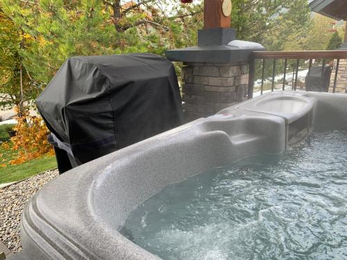 a hot tub in a backyard with a black cover at Pinnacle Ridge Condos by Fernie Central Reservations in Fernie